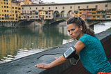 Serious fitness woman standing in front of ponte vecchio in flor