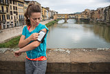 Fitness woman using cell phone in front of ponte vecchio in flor