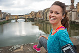 Portrait of happy fitness woman in front of ponte vecchio in flo