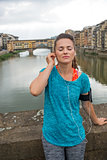 Fitness woman listening music in front of ponte vecchio in flore