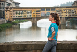 Fitness woman standing in front of ponte vecchio in florence, it