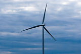 Single wind turbine on dark cloudy sky