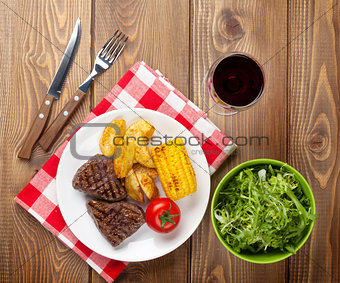 Steak with grilled potato, corn, salad and red wine