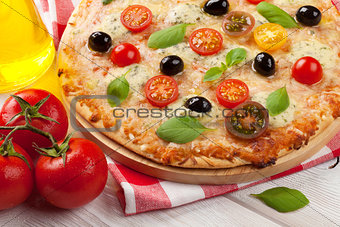 Italian pizza with cheese, tomatoes and basil