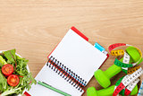 Healthy food, dumbells, tape measure and notepad for copy space