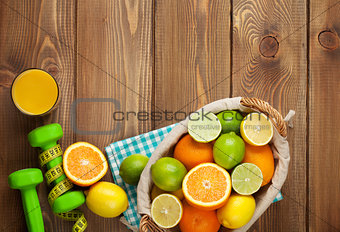 Citrus fruits in basket and dumbells. Oranges, limes and lemons