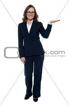 Woman in business attire posing with an open palm