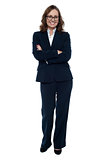 Executive in business attire standing arms folded