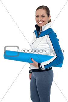 Woman carrying blue yoga mat