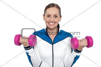 Happy woman carrying dumbbells in both hands