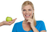 Attractive woman is being offered a green apple