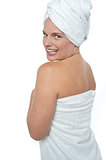 Hot woman in bath towel turning back towards camera
