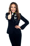 Joyous young stewardess gesturing thumbs up