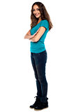 Stylish woman standing sideways with arms crossed