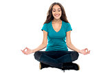 Smiling woman meditating in lotus position