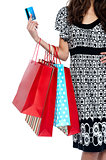 Stylish woman walking with shopping bags and credit card