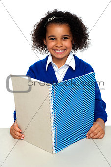Smiling school girl learning weekly assignment