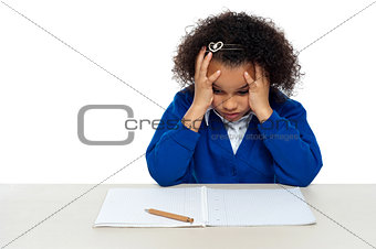 Stressed out primary girl child holding her head