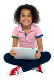 Cool girl kid sitting on the floor holding tablet pc