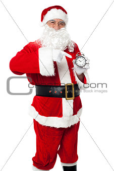 Santa pointing at an antique time piece