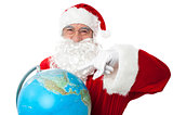 Expressionistic Santa pointing at north pole on globe