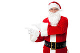 Santa pointing at blank copy space area