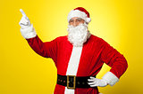 Cheerful Santa pointing away. Copy space concept.