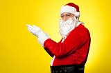 Side profile of Santa facing camera with open palms