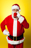 Portrait of a aged Santa sipping coffee
