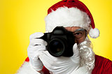 Aged Santa adjusting camera lens before click