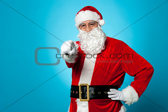 Handsome man in Santa costume pointing at you