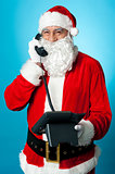 Modern Santa passing greetings over a phone call