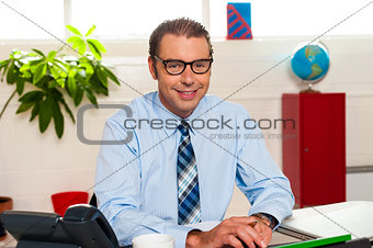 Bespectacled senior manager working in his office