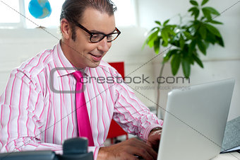 Busy employee in office working on laptop