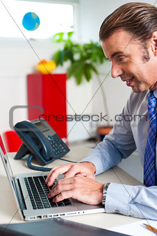 Businessman typing report on a laptop