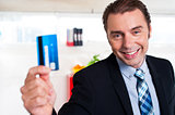Handsome male executive holding cash card