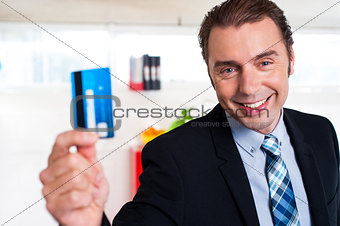 Handsome male executive holding cash card