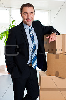 Executive with his hand placed on pile of cardboard cartons