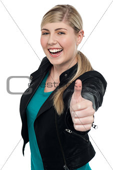Joyful blonde teen gesturing thumbs up