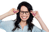 Joyous woman holding her spectacles