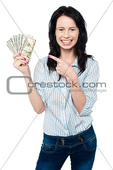 Pretty woman holding up fan of dollar notes