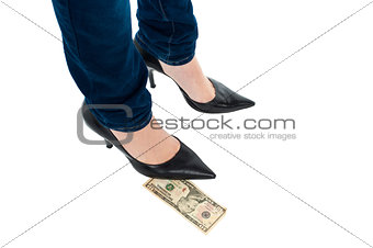 Woman in stilettos standing over ten dollar note