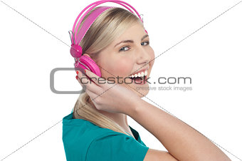 Joyous blonde teen listening to lively music