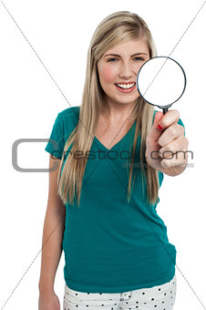 Attractive girl holding magnifying glass