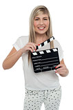 Cheerful teen girl with clapboard in hand