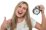 Excited girl holding old fashioned alarm clock
