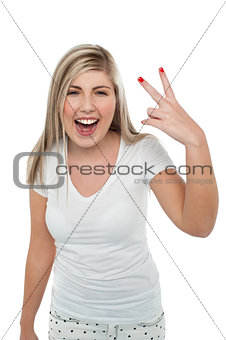 Gorgeous blonde girl gesturing victory sign