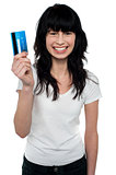 Happy young woman showing credit card