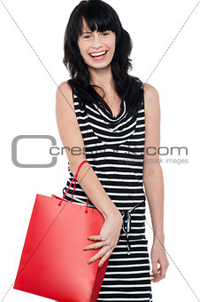 Joyous brunette posing with red shopping bag