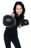 Smiling young female boxer ready to punch you